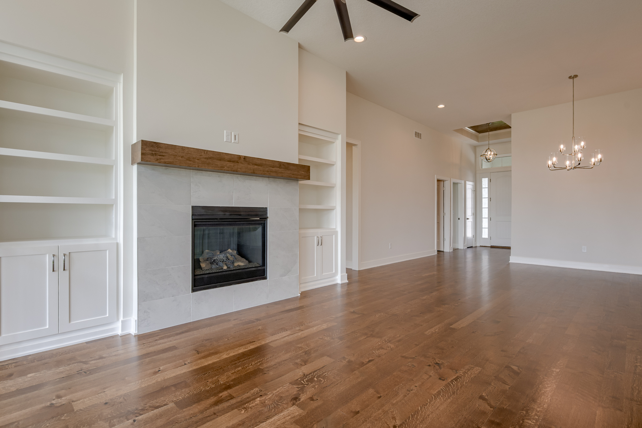 The Truman reverse 1.5-story floor plan great room with gas fireplace and built-in bookshelves by Patriot Homes.