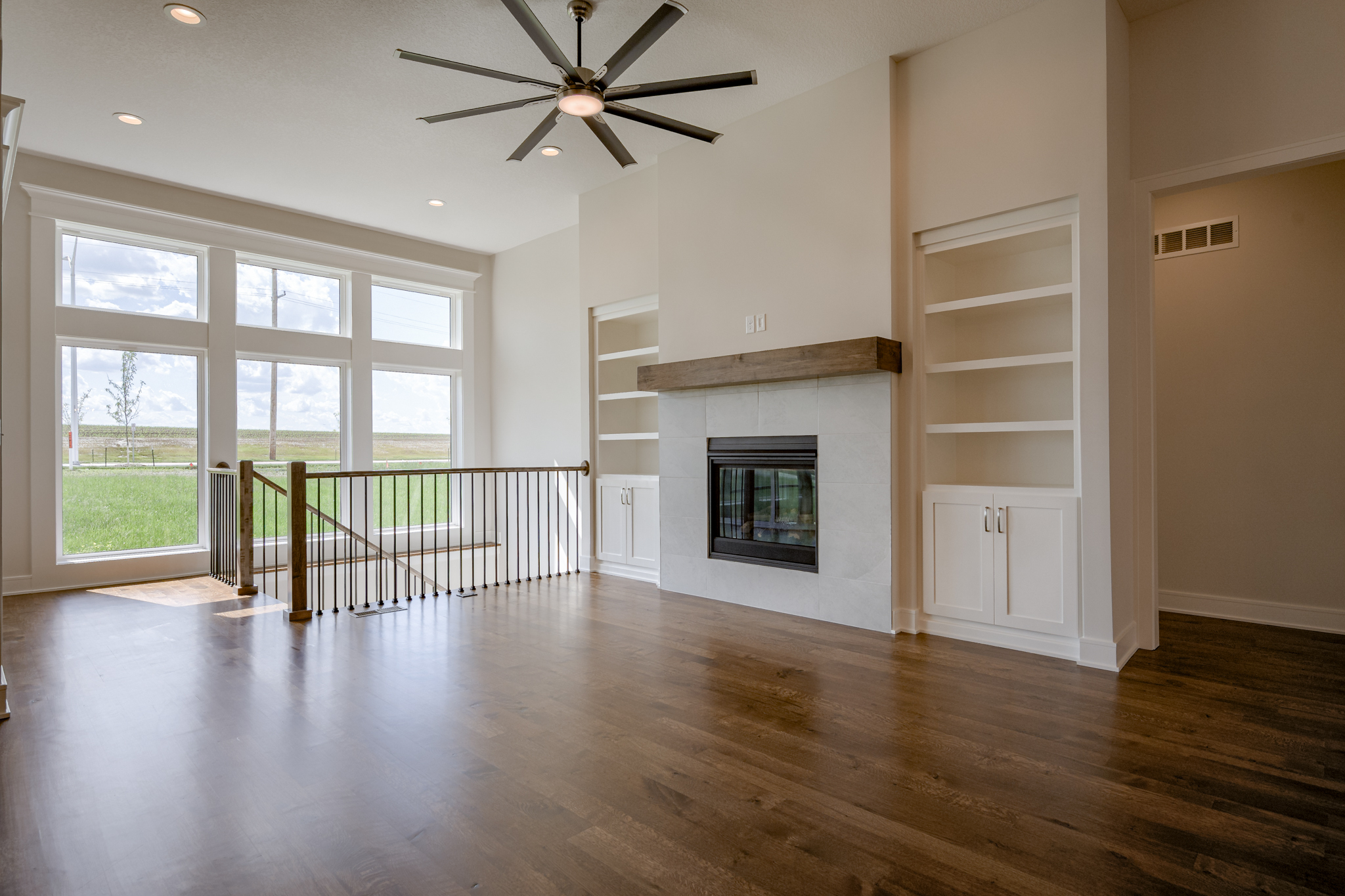 The Truman reverse 1.5-story floor plan great room with gas fireplace and built-in bookshelves by Patriot Homes.