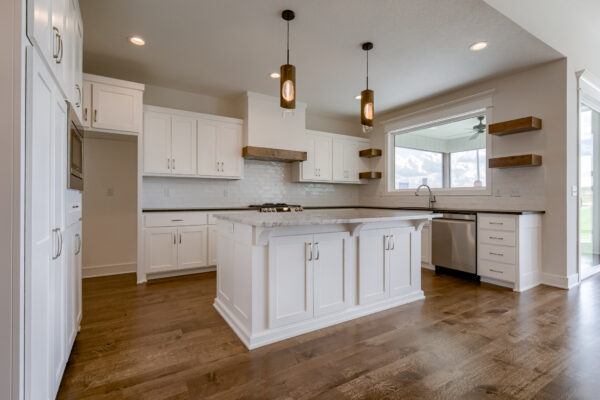 The Truman reverse 1.5-story floor plan kitchen with large granite island by Patriot Homes.