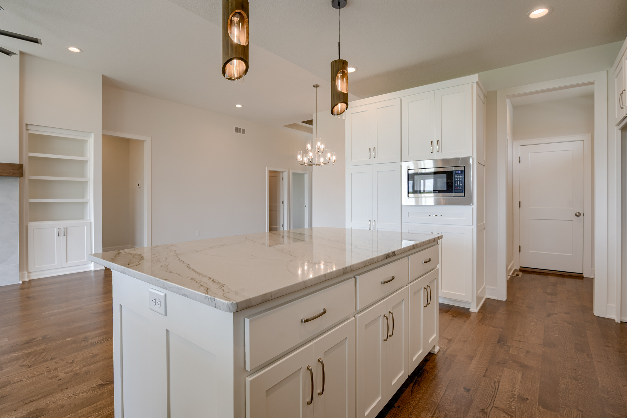 The Truman reverse 1.5-story floor plan kitchen with large granite island by Patriot Homes.