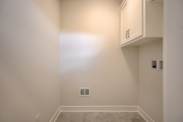 The Truman reverse 1.5-story floor plan main level laundry room by Patriot Homes.
