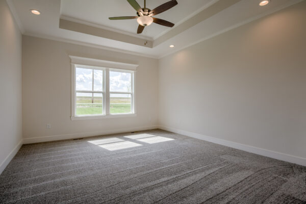 The Truman reverse 1.5-story floor plan main level master bedroom with tray ceiling by Patriot Homes.