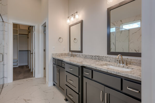 The Truman reverse 1.5-story floor plan master bathroom with double vanities by Patriot Homes.