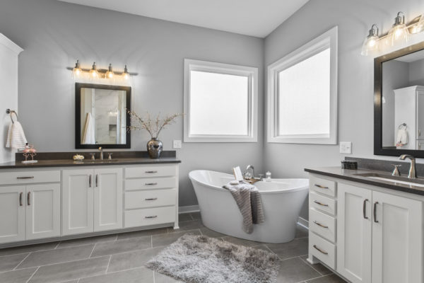 The Jefferson 1.5-story floor plan main level master bathroom with double vanities and free-standing bathtub.