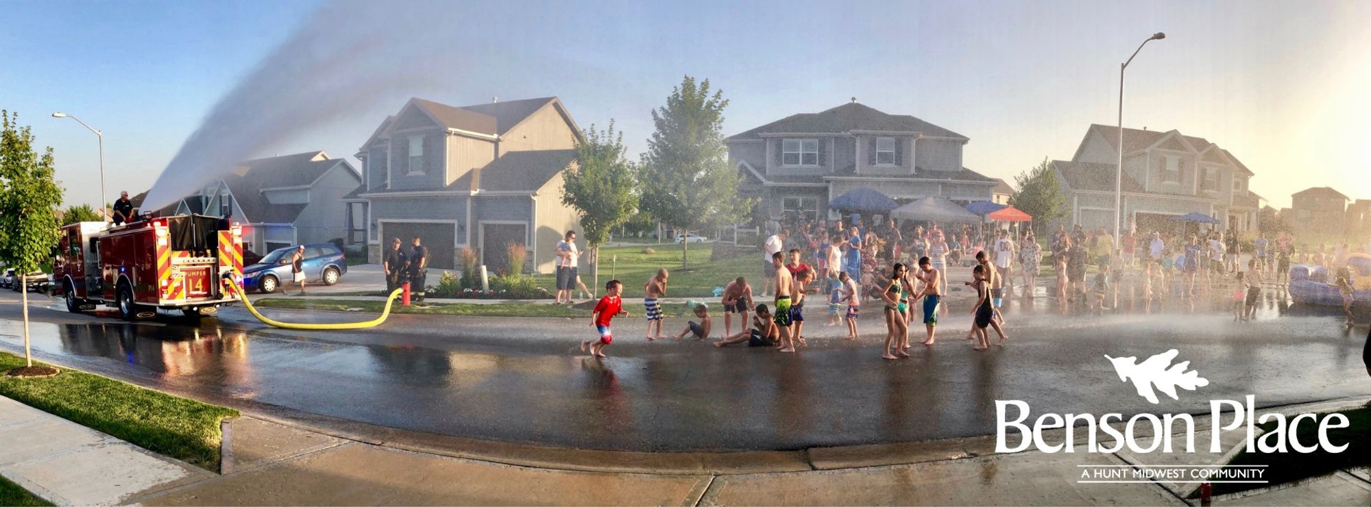 Benson Place neighborhood street with kids playing in water.