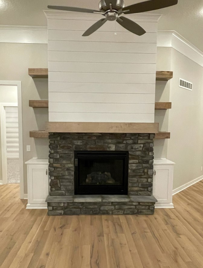 The Taft reverse 1.5-story floor plan great room stone fireplace by Patriot Homes.