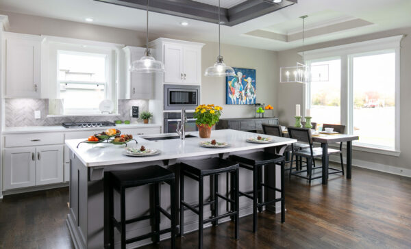 The Franklin, a reverse 1.5-story floor plan, kitchen features a large island with quartz counter top, white custom cabinets, and a large breakfast nook.