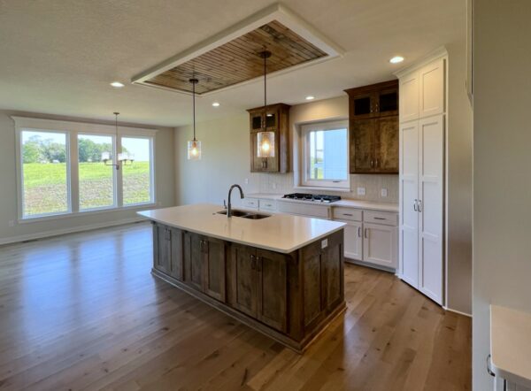 The Taft reverse 1.5-story floor plan kitchen with stained and painted enameled white cabinets and breakfast nook dining area.