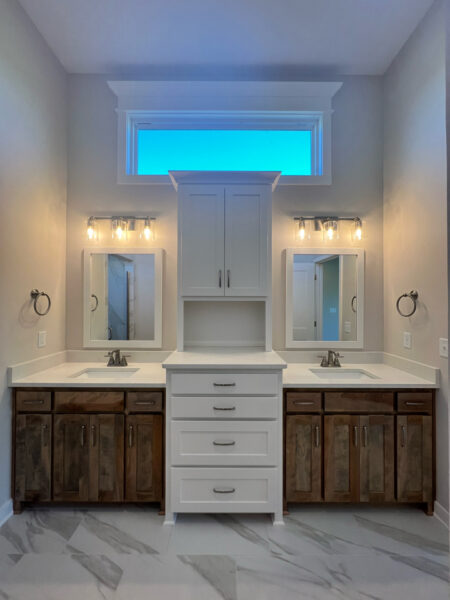 The Taft reverse 1.5-story floor plan master bathroom double vanity with stained and enameled painted white cabinets.